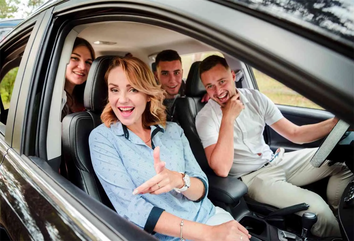 Driver and passengers smiling inside a car